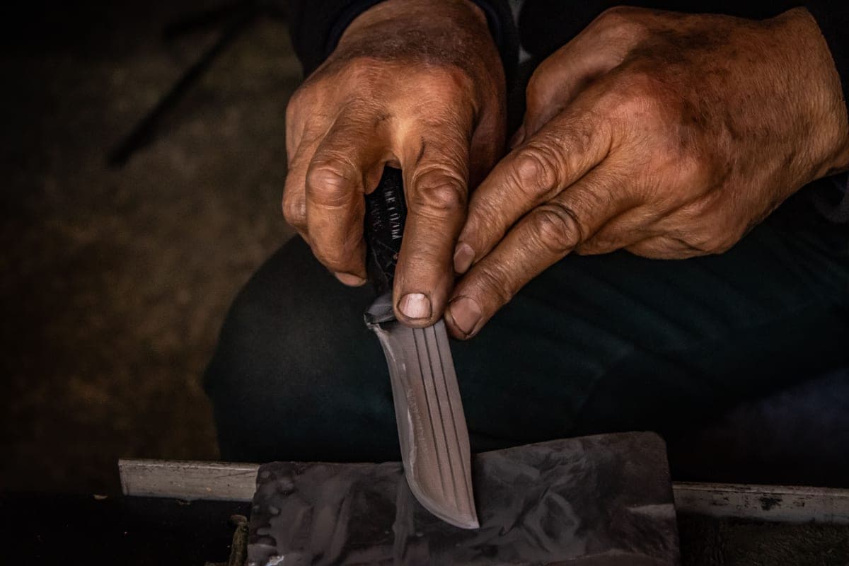 A knife edge being drawn across a sharpening whetstone